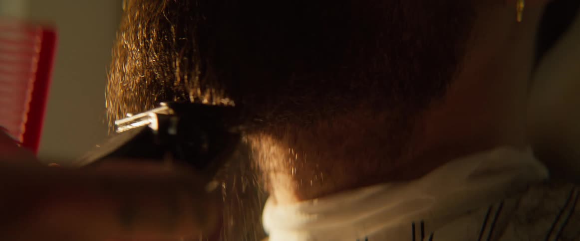 An extreme closeup of the lower part of a mans face as he shaves his beard