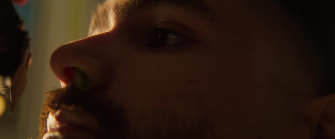 A man blinks as his beard is trimmed