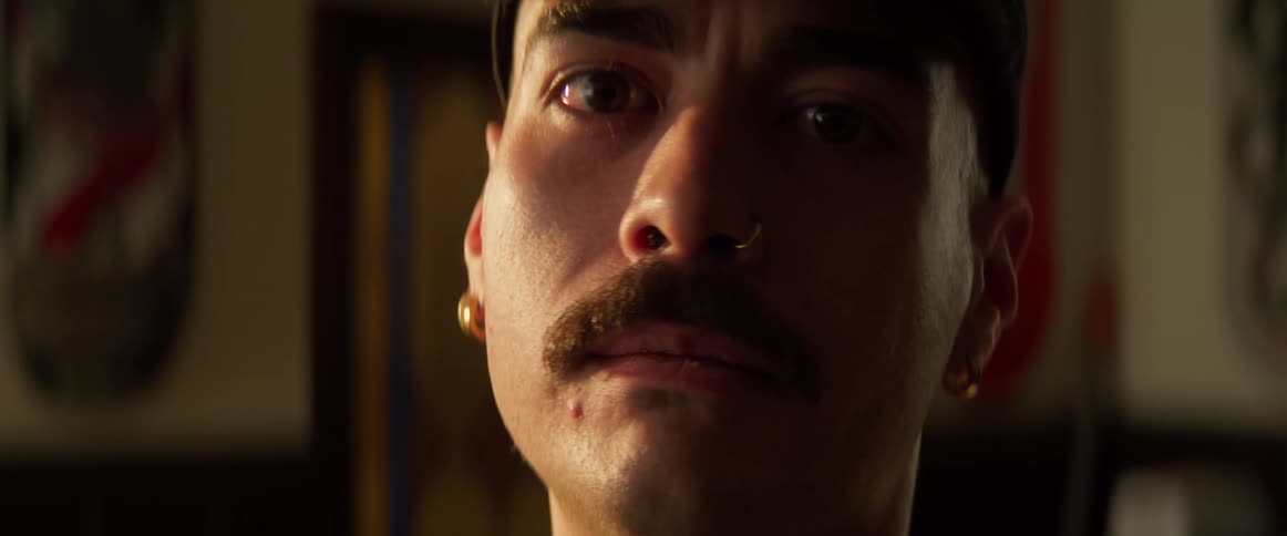 Guy with a mustache turning to look at the camera