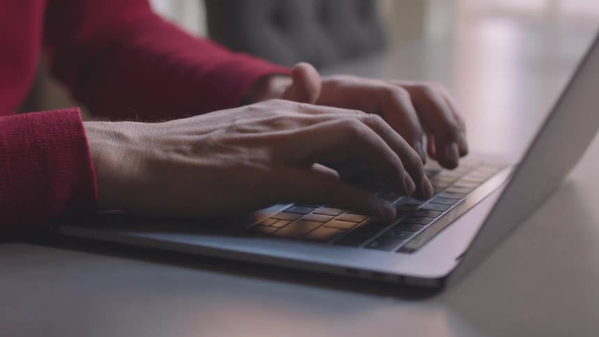 Hands typing on a computer