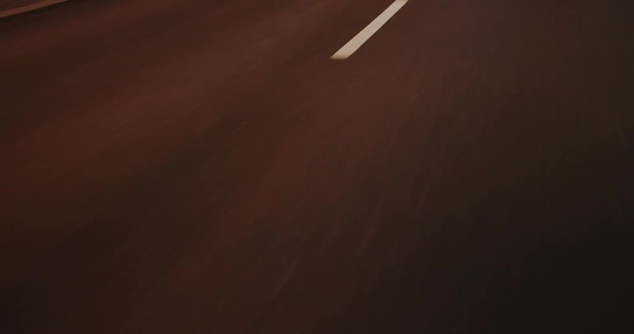 A dark asphalt surface with white lines at night
