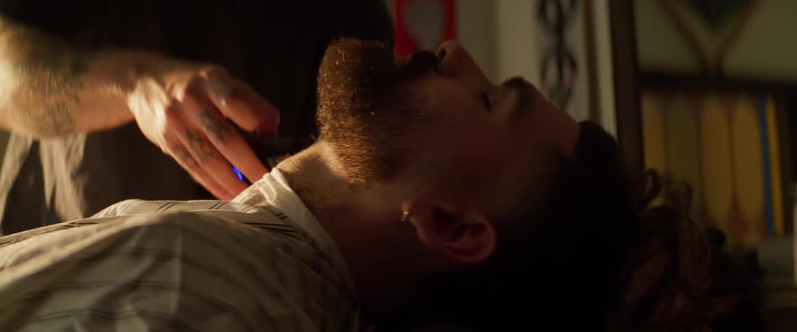 Barber grooming clients beard in barbershop