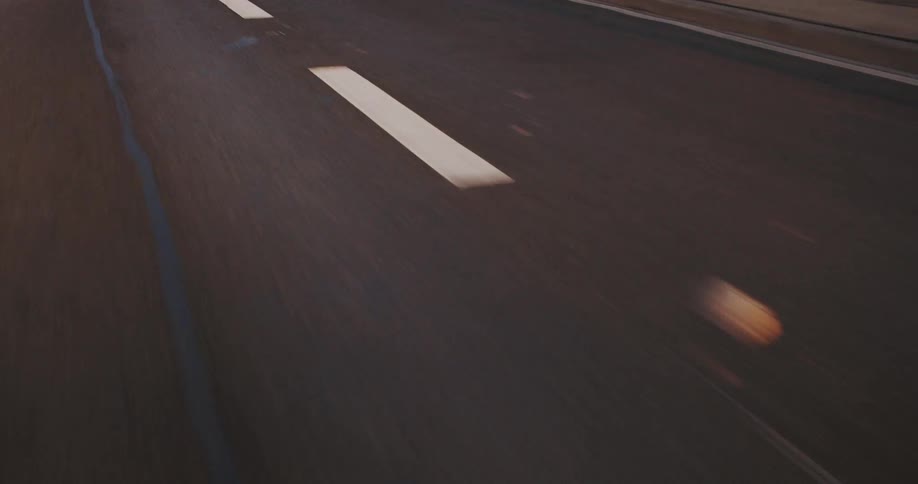 A dark asphalt surface shows a white diagonal line and a faint blue line