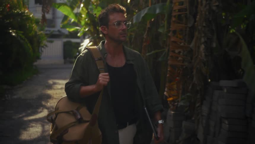 A man walks down a path from the hotel