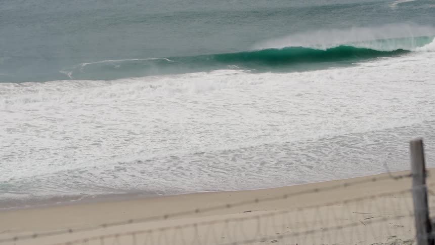 Ocean waves roll into a sandy beach