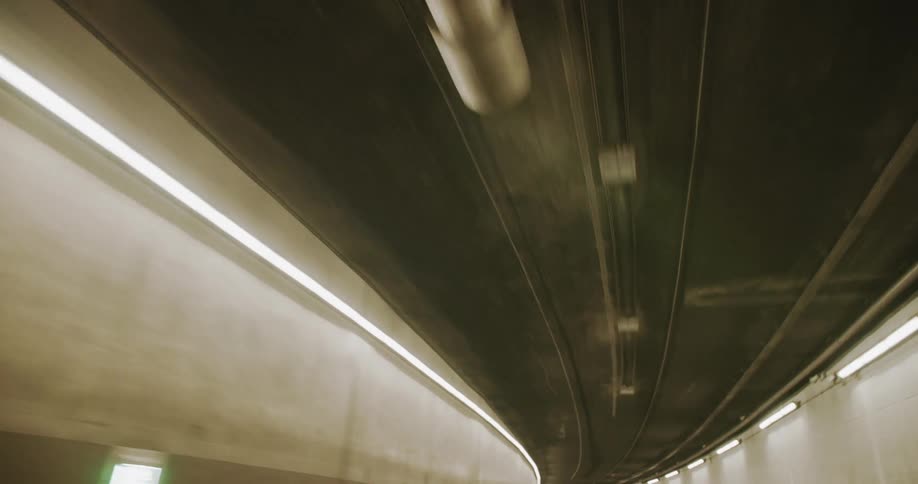 An empty tunnel with traffic out on the other side