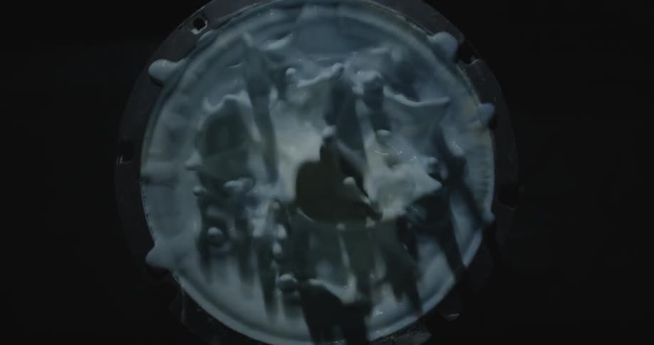 An overhead view of paint in a can that is vibrating