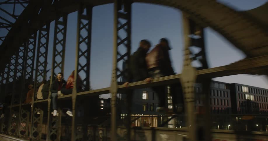 People are sitting on the bridge at night
