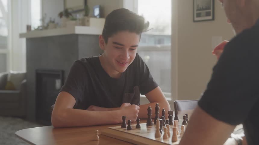 A father and son are playing chess