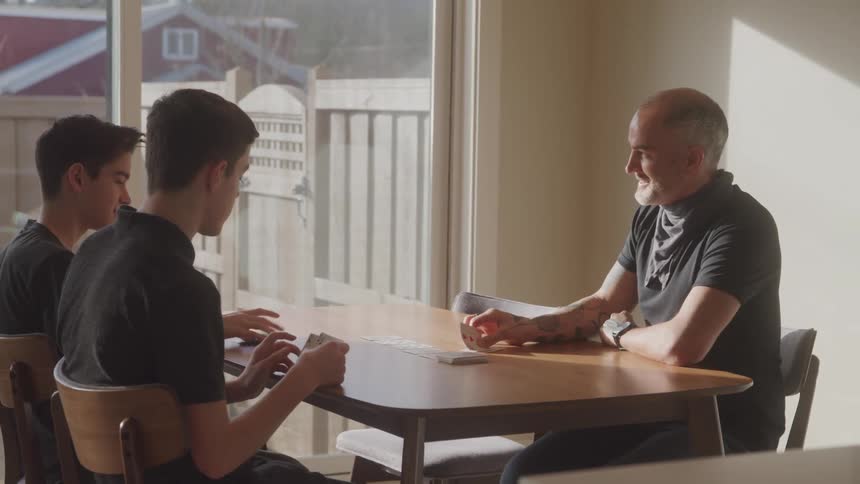 Father and sons playing cards