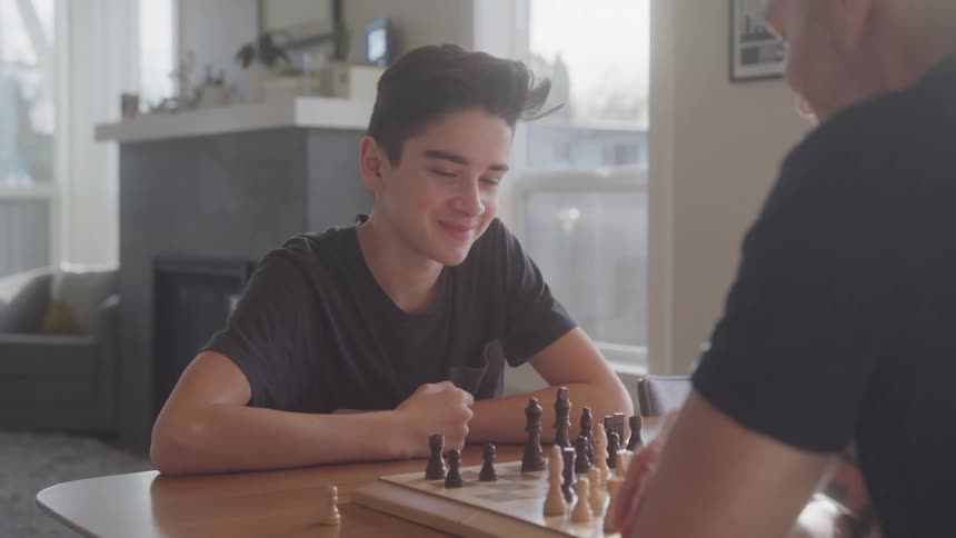 Boy playing chess and smiling