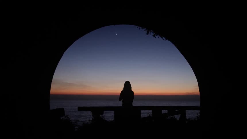 Woman stretching as the sun rises