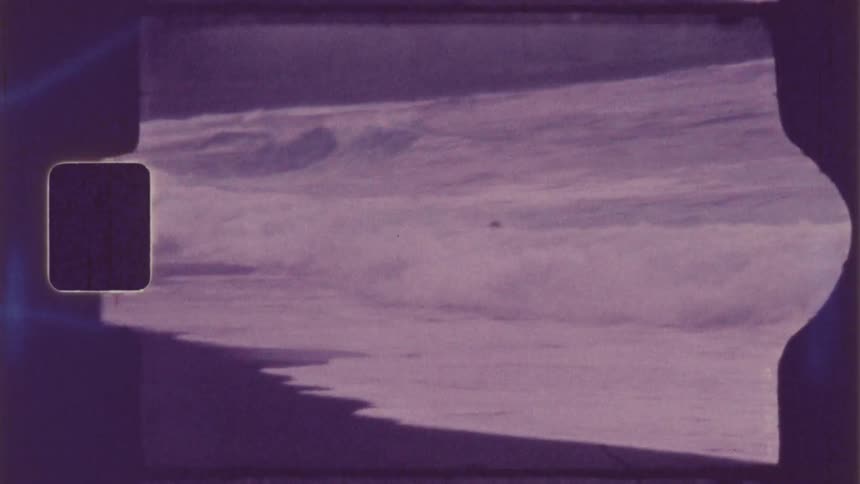 A teenager jumps into the waves on the beach