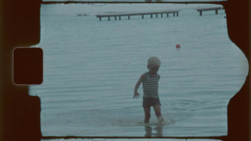A child wades through the water on the beach