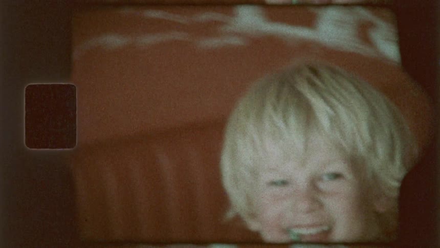 A child is laughing and jumping on the bed