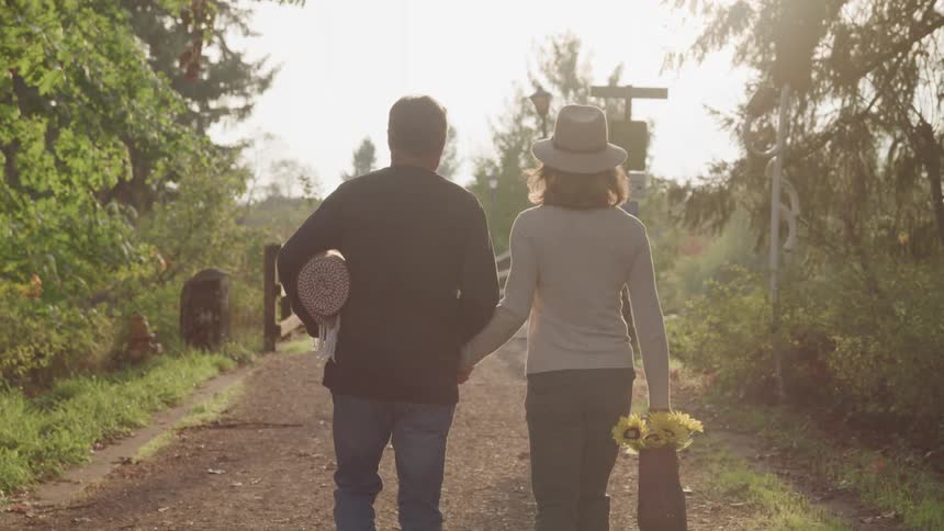 A couple hold hands and hike together