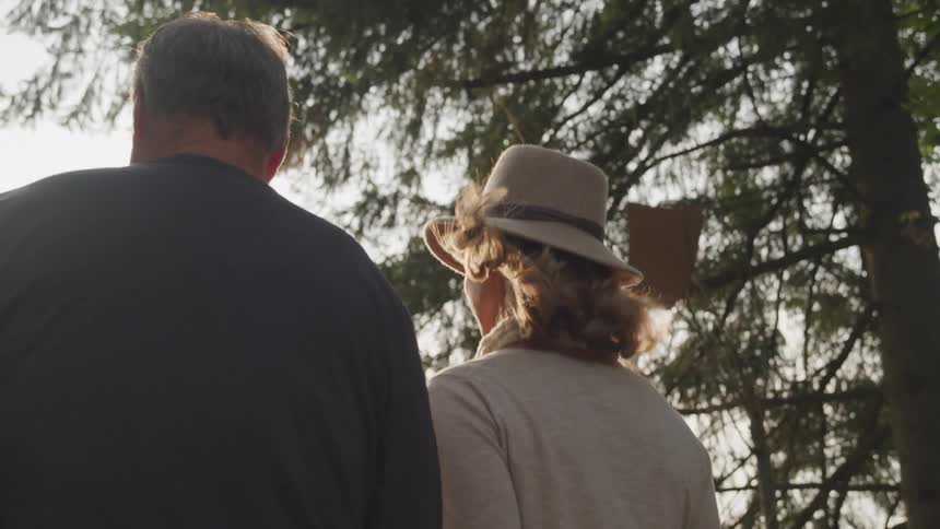 A man and woman are walking in the forest