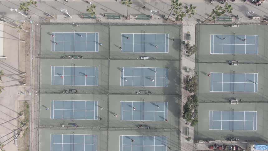 Overhead view of people playing tennis on tennis courts at private club