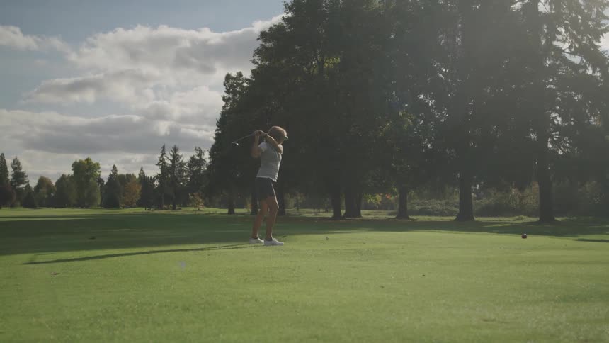 A woman drives the golf ball