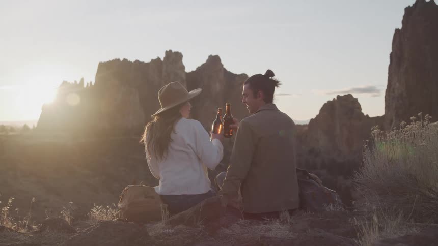 A couple have a beer together in the canyon