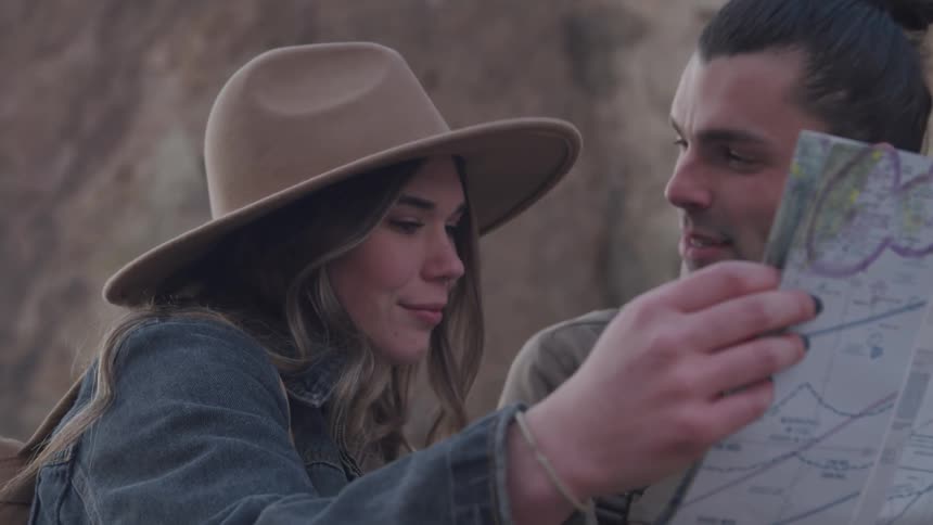 A man and woman read a map and laugh