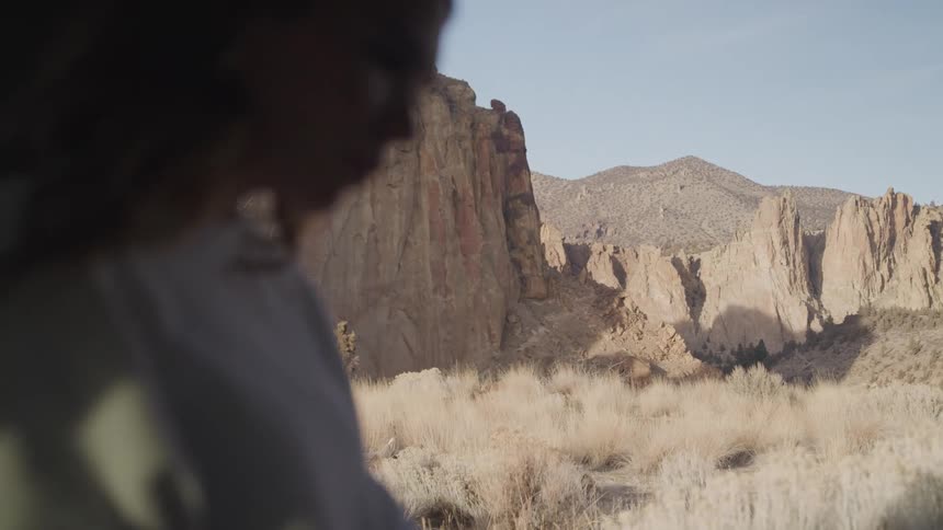 The woman is sitting in front the desert