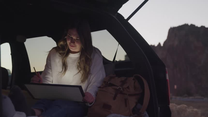 Girl sitting on a machine drawing on a tablet