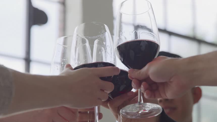 Friends toasting glasses with red wine