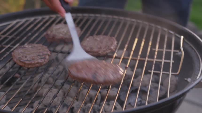 Flipping burgers outdoors on a barbeque