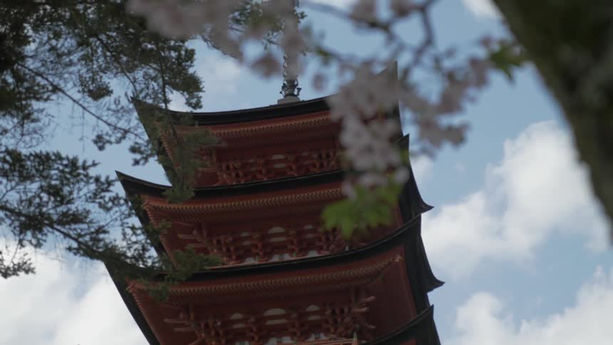 A tall tower has levels and trees around it