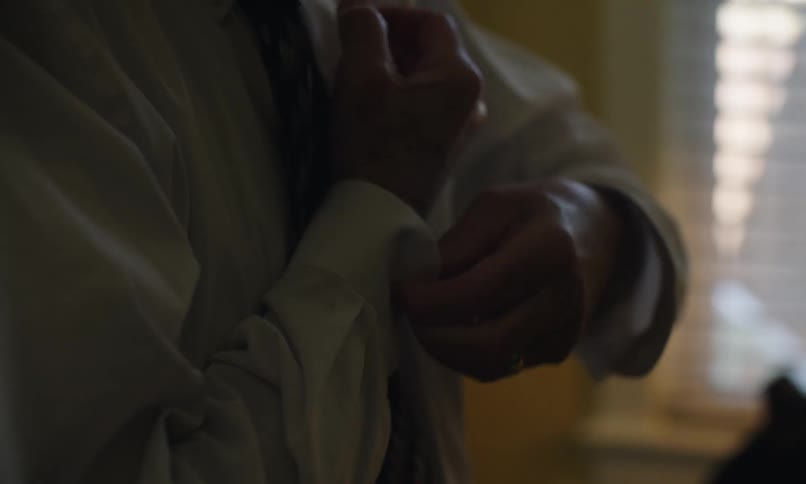 Man buttoning his shirt sleeves