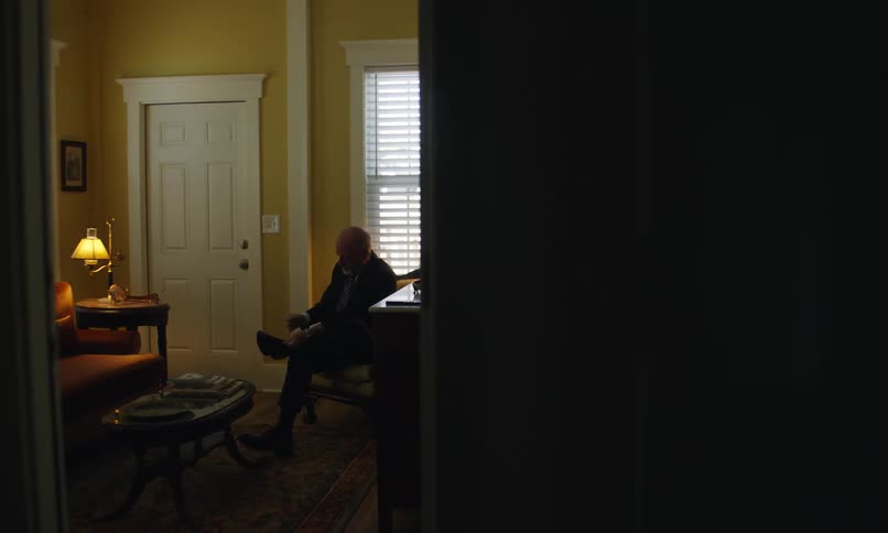 A man is putting on his shoes at home