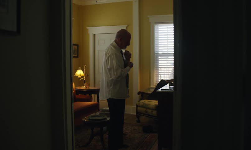 Man buttons his cuffs while getting dressed
