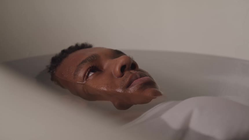Boy almost immersed in a bathtub