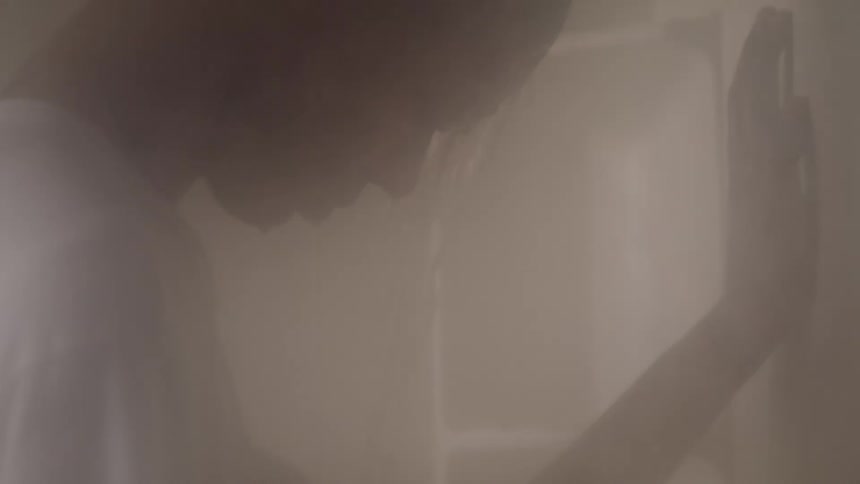 Man inside a shower dressed whose water is running over him