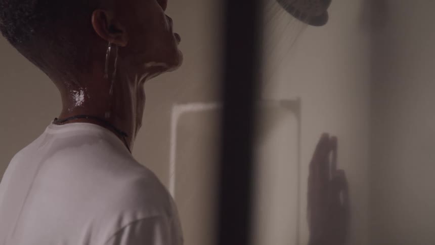 A teenager is showering while dressed