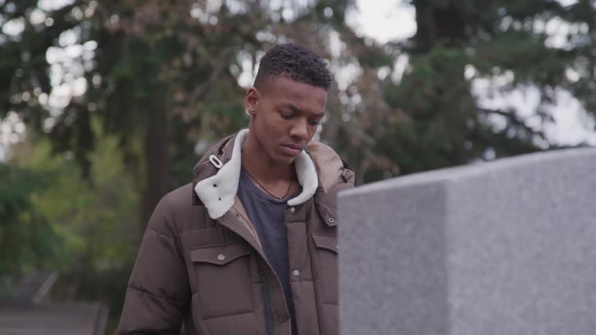 A teenager is visiting a grave