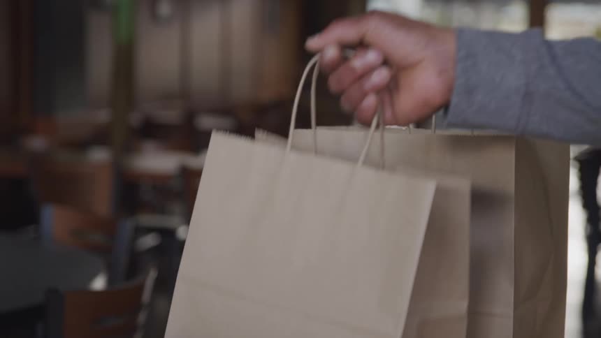 Hands taking paper bags