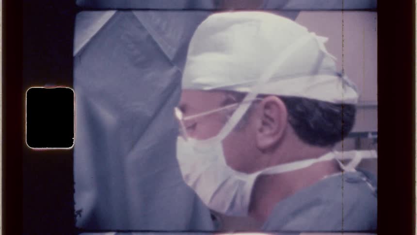 Vintage footage of obstetrician in delivery room about to deliver a baby