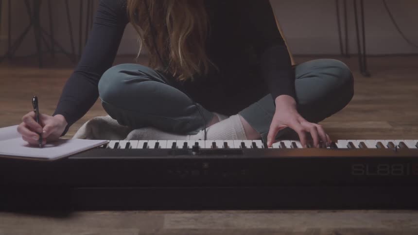 A woman takes notes as she is playing music