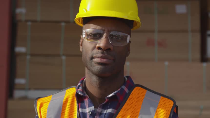 Man dressed for work with helmet and goggles turning toward the camera