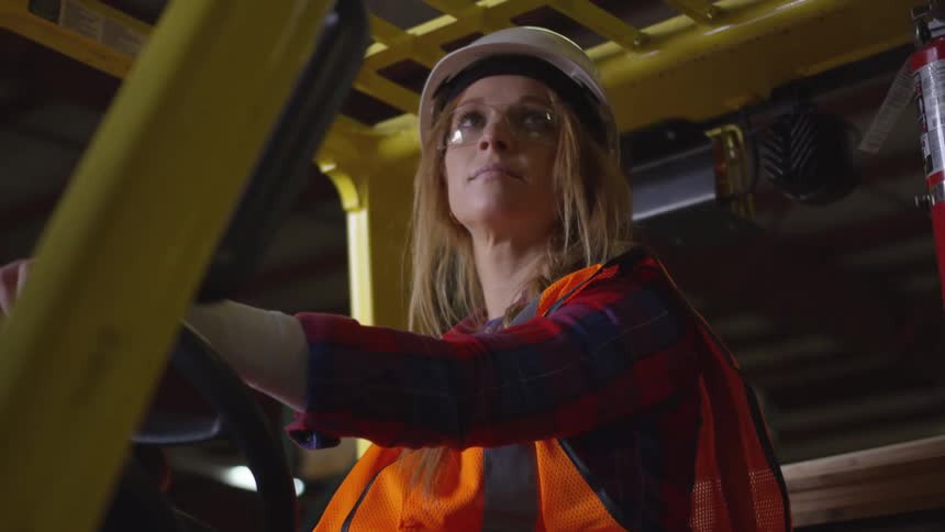 A woman is driving a forklift