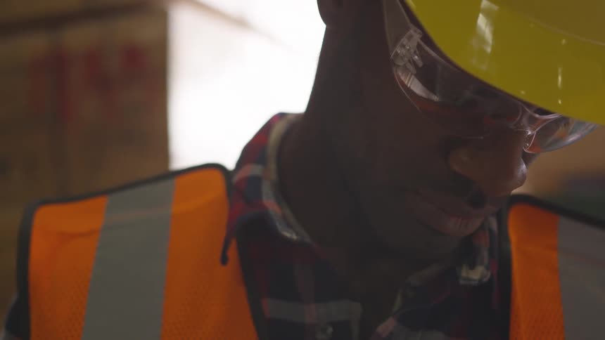 A worker is looking down in the warehouse