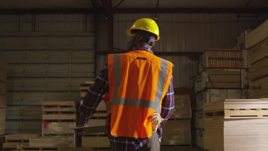 Man looks from side to side while walking through an open warehouse