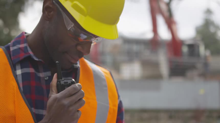 Guy in work uniform talking through a walkie talkie