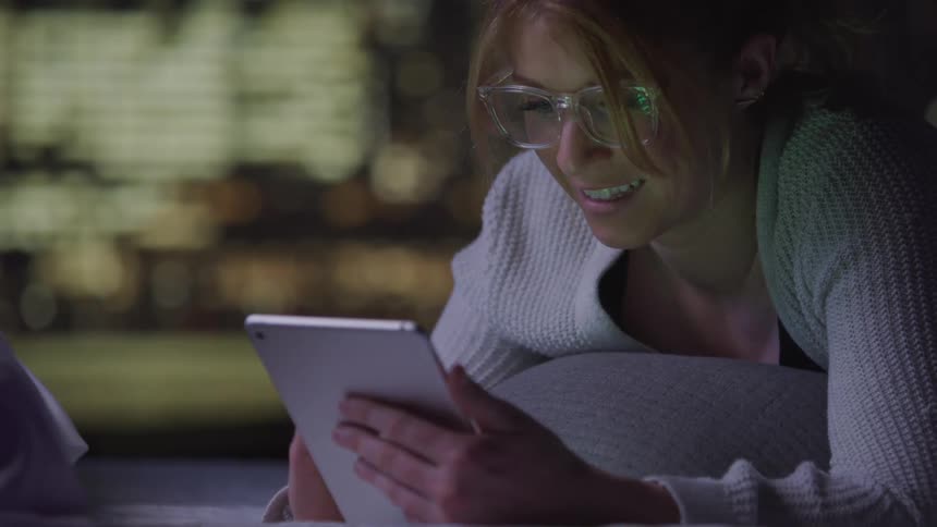 A woman is typing on her tablet