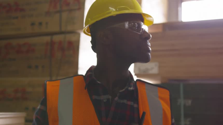 Man in a warehouse raises his head to look to his side