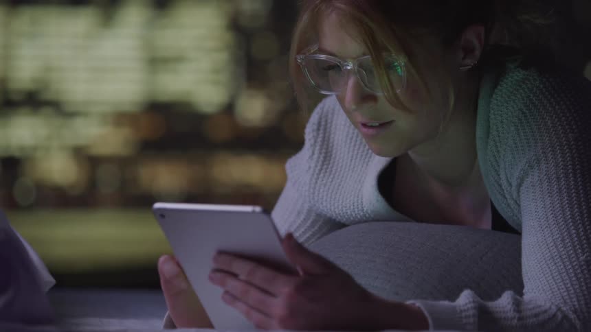 A footage of a lady operating a tablet