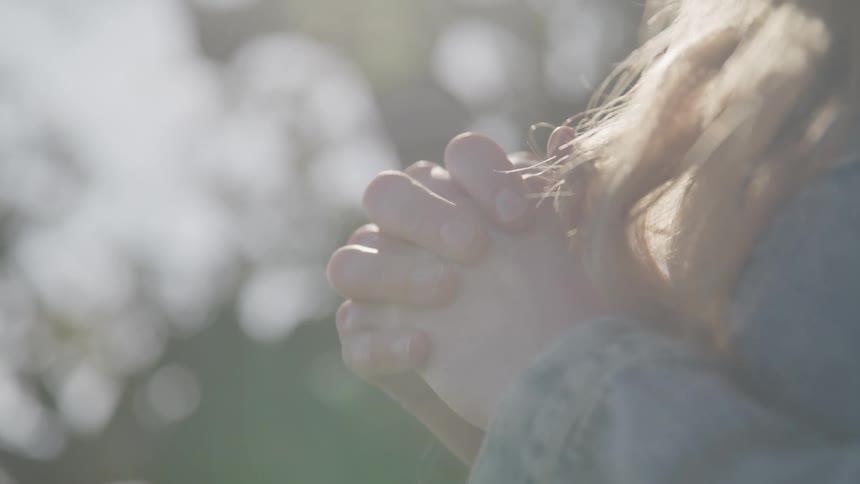 A woman is praying on a sunny day