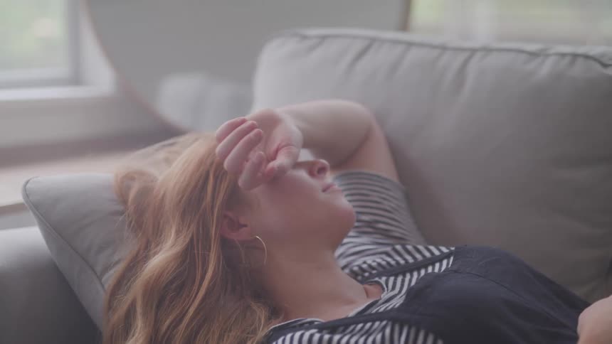 A woman is resting on the couch